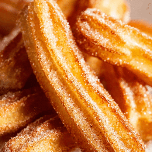 Close-up of crispy air fryer churros with visible cinnamon sugar coating and golden texture.