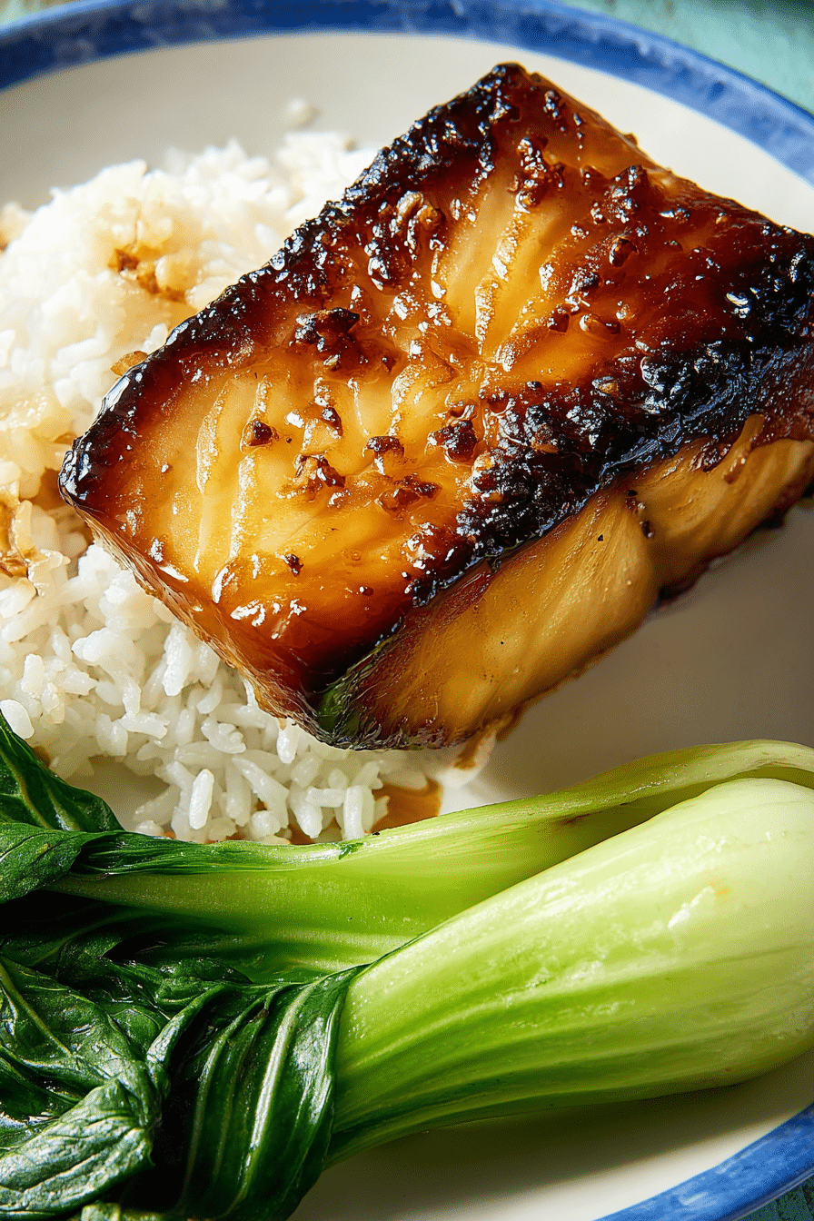 Air fryer miso black cod fillet with rice and bok choy on a white and blue plate